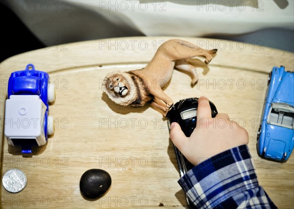 High Angle View of Toddler's Hand and Toys on High Chair