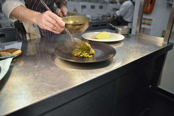 Chef spooning Lentils onto Plate