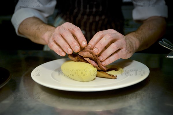 Chef stacking Meat on top of Creamed Potatoes