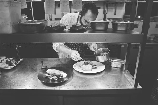 Chef plating Food in Restaurant Kitchen