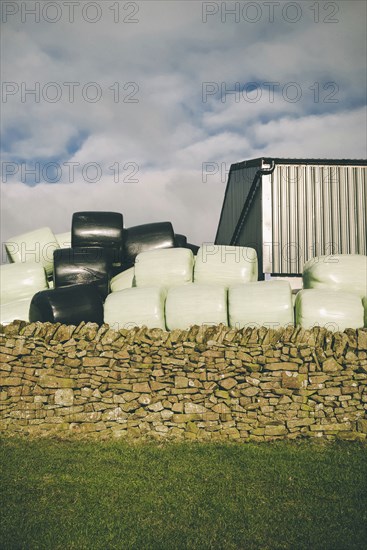 Wrapped Bales of Hay behind Old Stone Wall