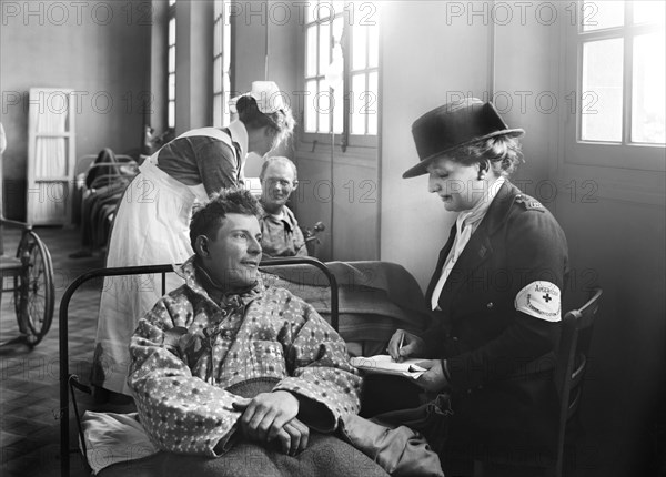 Member of the American Red Cross Home Communication Service writing a letter for American Soldier in Corridor in the American Military Hospital No. 1