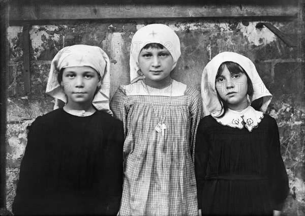 Three Refugee Children playing as Red Cross Nurses