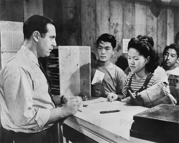 Young woman applies for a money order at Center Post Office from non-Evacuee Official