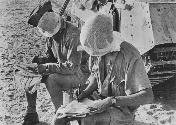 Two British Soldiers with their heads covered by Mosquito Nets