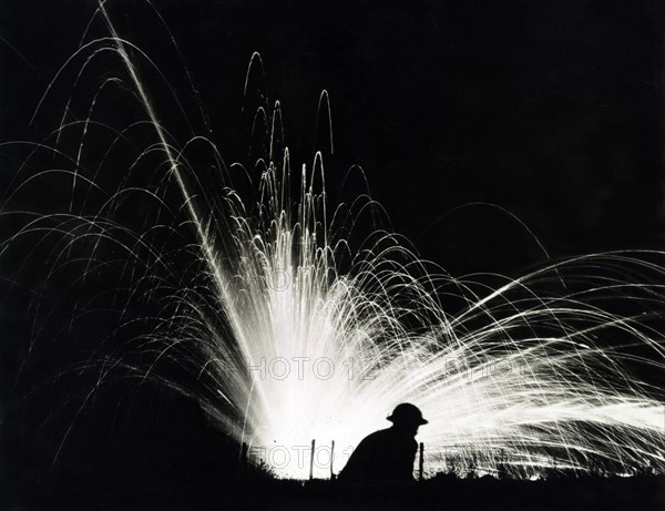 Silhouette of Soldier against Phosphorous Streamers from Bombs Exploding during Night Attack