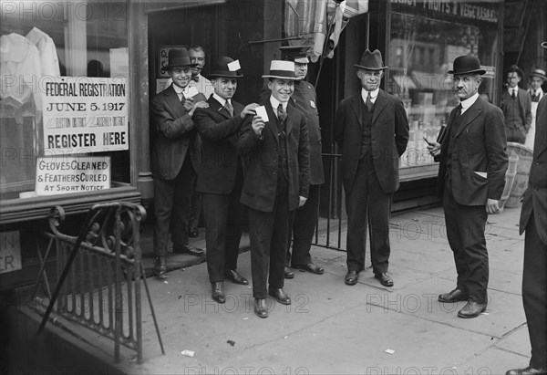 Men holding Draft Cards coming out of Building after registering for the Draft during World War I