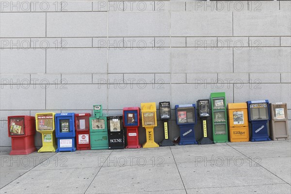 Row of Colorful Newspaper Boxes on Sloping Sidewalk