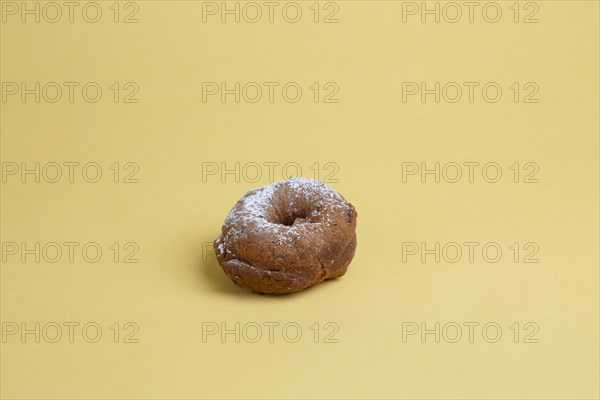 Doughnut with Powdered Sugar on Yellow Background