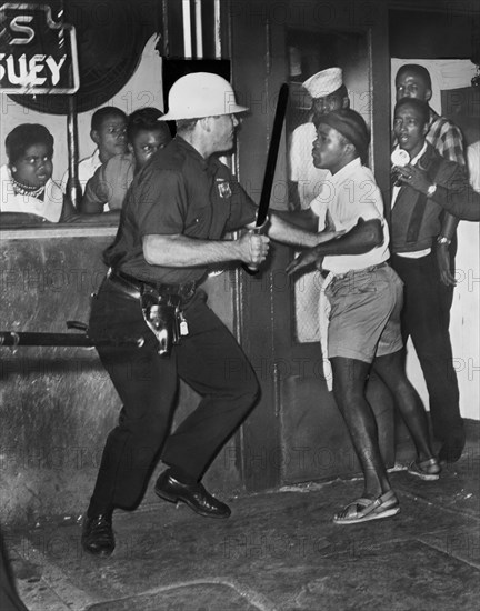 Policeman confronts group of People after night of rioting due to fatal shooting of Teen James Powell by Police Officer Lt. Thomas Gilligan, 126th St. and Seventh Avenue, July 1964