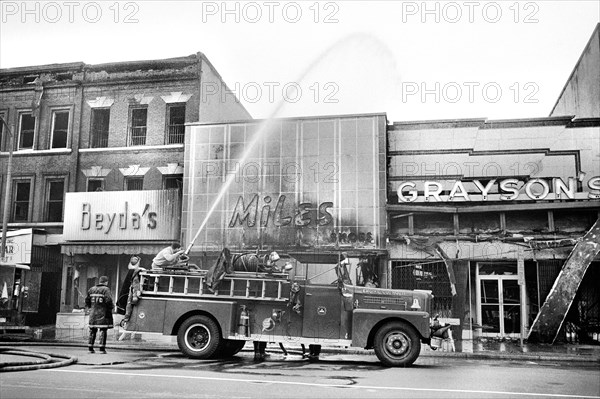firefighters spraying water on shops that were burned during Riots that followed the Assassination of Martin Luther King, Jr., April 8