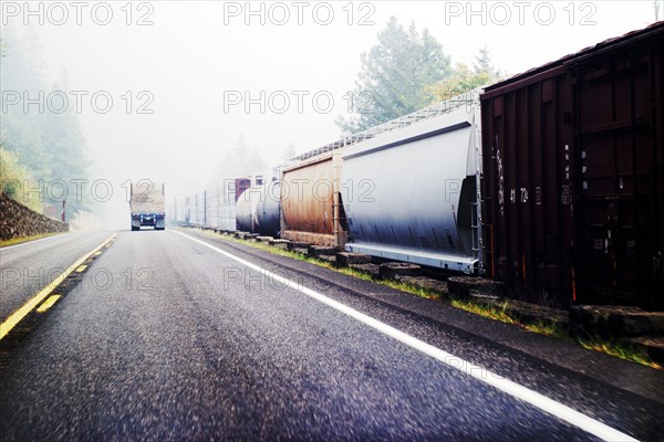 Truck on Highway next to Freight Train, Wildfire Smoke obstructing Distance,
