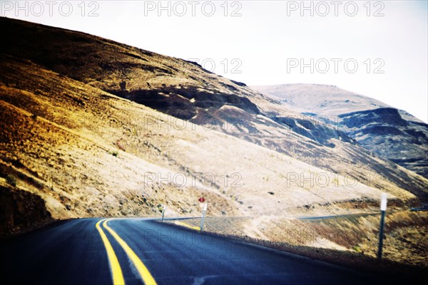 Empty Two-Lane Highway along Hillside,,