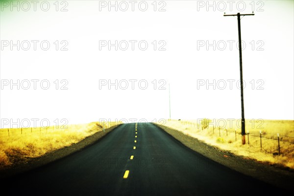 Empty Two-Lane Highway through Golden Landscape ,,