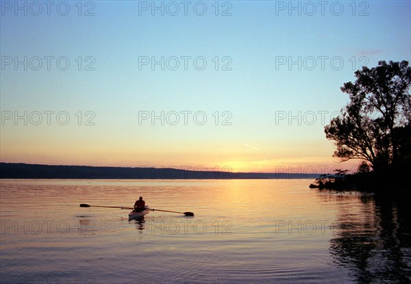 Silhouette of Man rowing Boat on Lake at Sunset,,