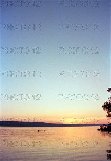 Silhouette of Man rowing Boat on Lake at Sunset,,