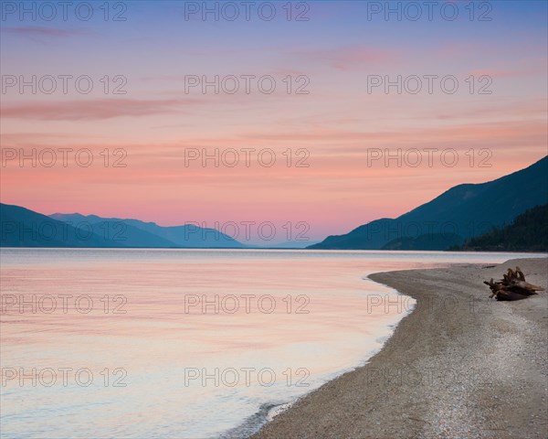 Shoreline with Mountains in Background at Sunset,,