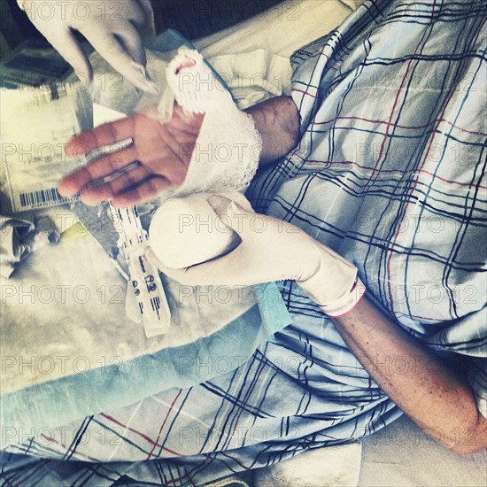 High Angle View of Woman with Injured Hand in Hospital Bed,,