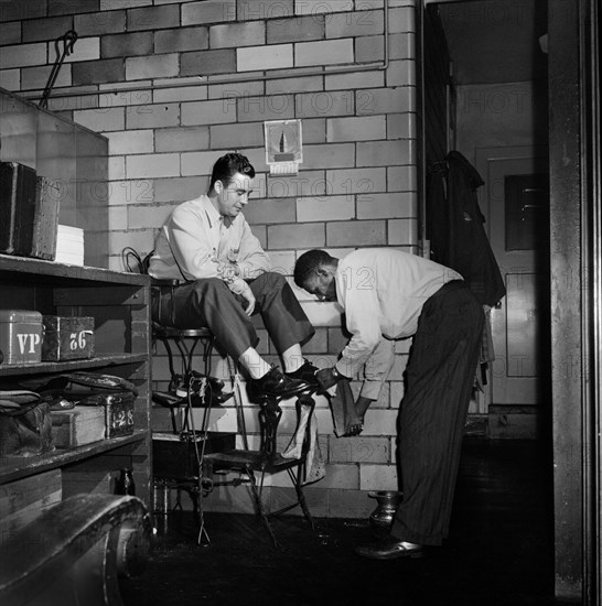 Greyhound Driver getting his Shoes shined by a Porter at the Garage, Pittsburgh