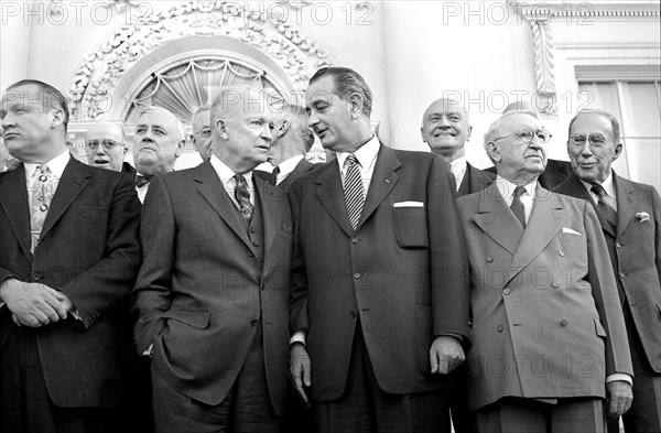 U.S. President Dwight D. Eisenhower standing with U.S. Senator from Texas Lyndon B. Johnson (center), U.S. Secretary of State John Foster Dulles (right) and other guests