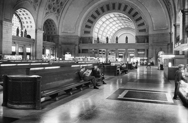 Passengers seated in long benches in the waiting room of Union Station, Washington