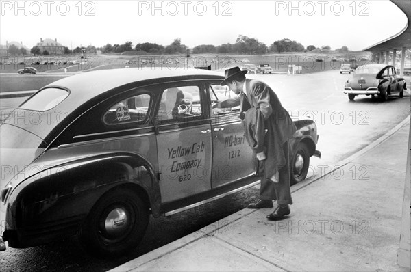 Man paying Taxi Driver upon arrival at Municipal Airport