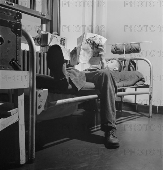 Sergeant George Camblair reading an article in a magazine while relaxing after dinner