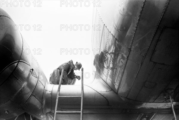 Mechanic Checking Fuel in Airplane on Rainy Day