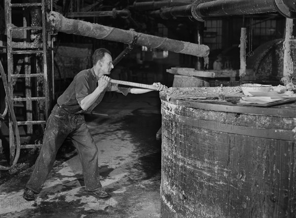 Worker stirring Paper Pulp in Large Vat