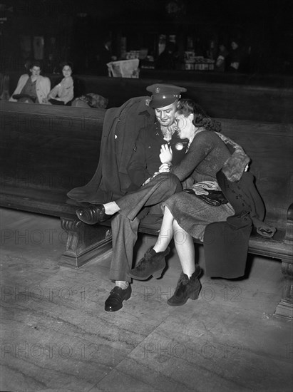 Soldier and Girl waiting for Train in Waiting Room