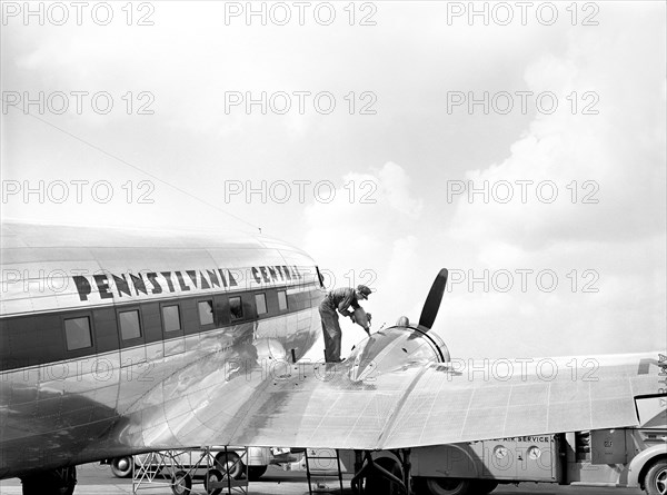 Mechanic adding Oil for the Airplane Engine prior to Takeoff