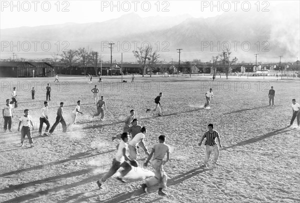 Boys playing Football on dusty Field