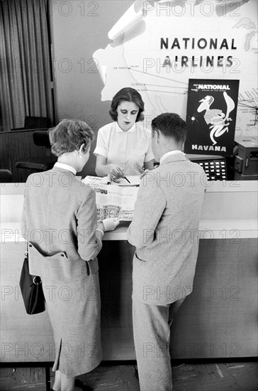 Couple scheduling trip at National Airlines Office