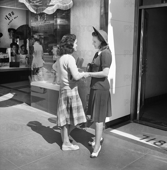 Two Young Adult Women talking on downtown Street