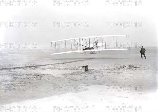 Wilbur Wright lying on machine