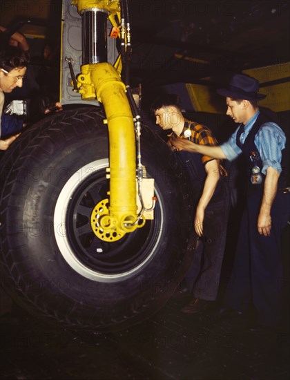 Workers inspecting landing wheel of Transport Plane