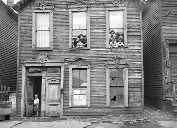 Group of People looking out of windows in rundown House