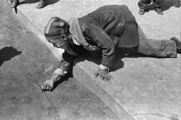 Young Boy playing Marbles