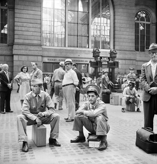 Civilians and Military Service Men waiting for Trains