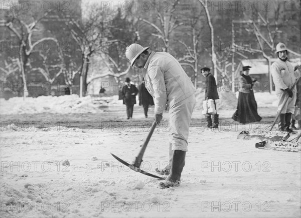 Man clearing street with pickaxe after snow storm