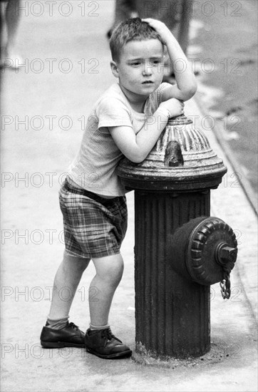 Young Boy leaning on Fire Hydrant