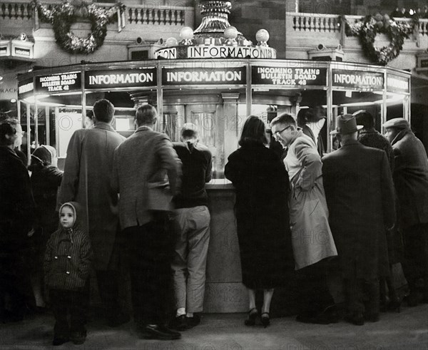 Group of People gathered around Information Booth