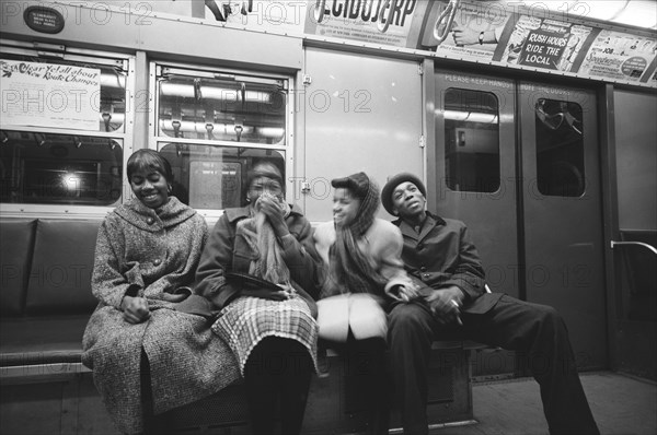 Four young adults sharing Laugh on Subway