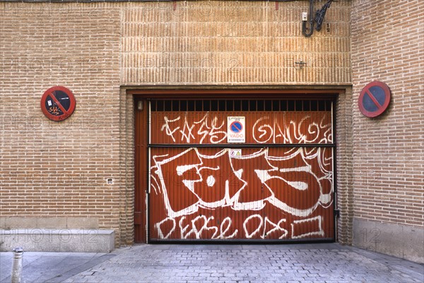 No parking sign at loading dock painted with graffiti