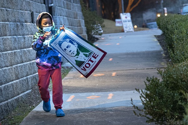 Young Boy carrying Congressman John Ossoff Banner after Campaign Rally