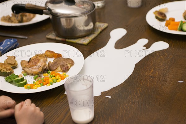 Cup of Spilled Milk on Dinner Table