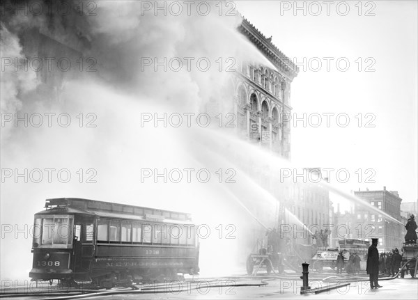 Fireman spraying water on burning building