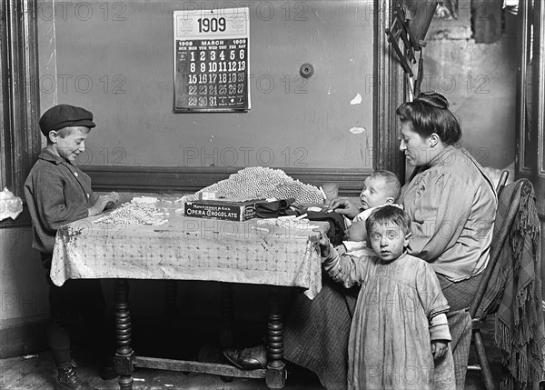 Woman and Young Boy rolling papers for Cigarettes