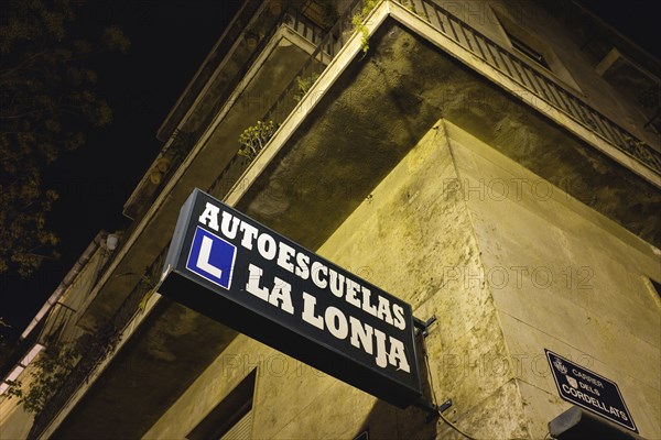 Low Angle View of Driving School Sign on Corner of Building at Night