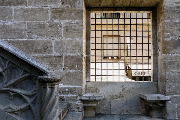 Two Stone Benches beneath Grated Window